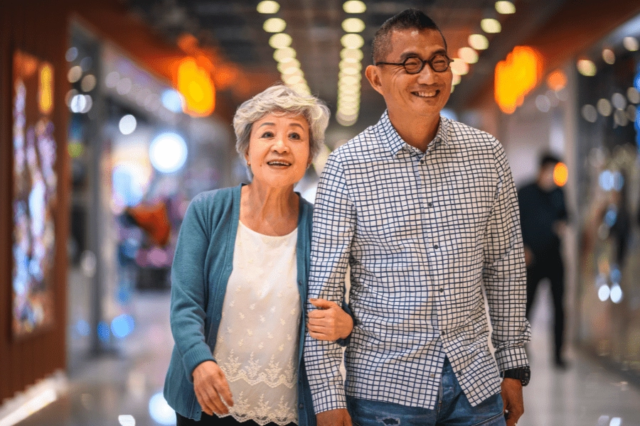 Senior Woman And Mature Man Walking Through Mall