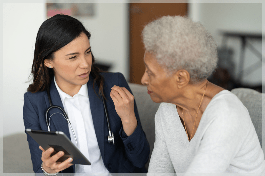 Pain Awareness Month - Elderly Woman and doctor talking on the couch - MeetCaregivers