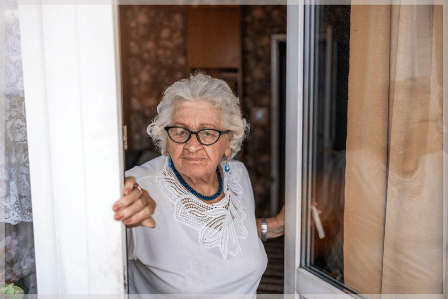 Depression in the elderly - Senior woman opening her door to look outside - MeetCaregivers