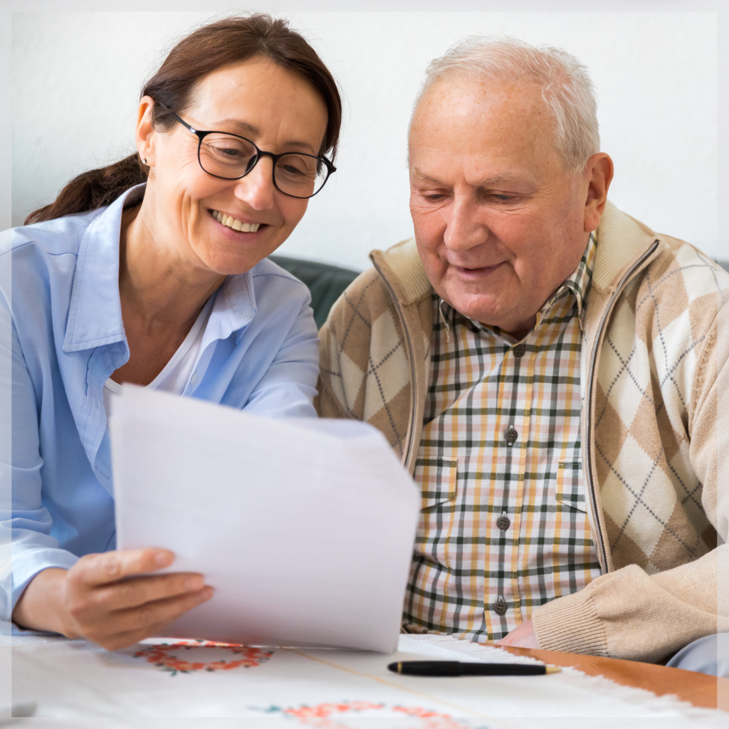 Geriatric care manager going over paperwork with smiling senior man – MeetCaregivers