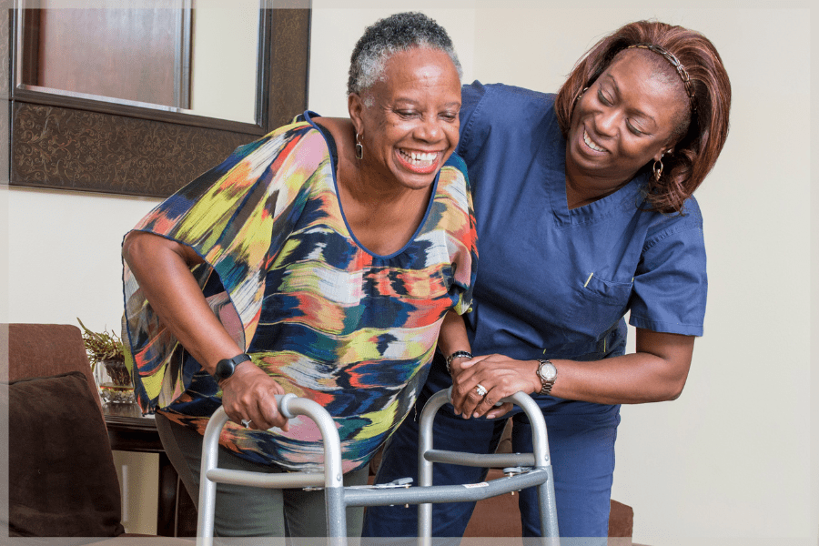 Care at home - Caregiver helping elderly woman use her walker - MeetCaregivers