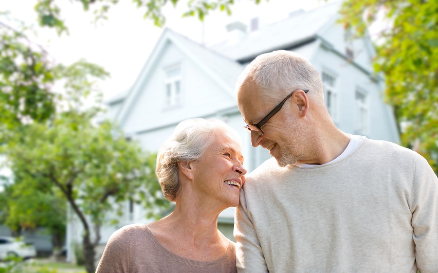 Aging In Place - A Senior Couple Standing In Front Of Their Home