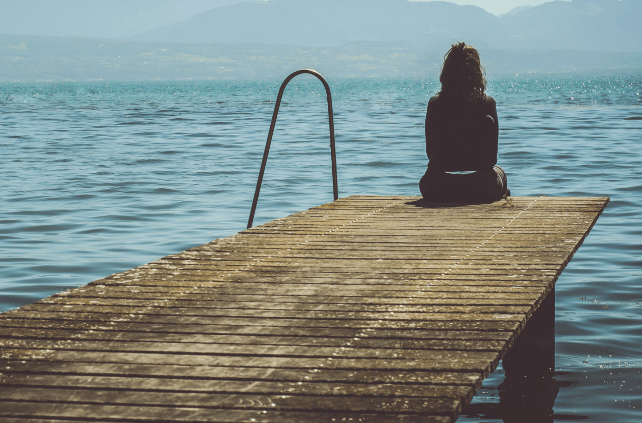 Senior Social Isolation - Woman Sitting Alone On A Dock