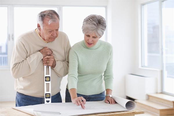 Aging In Place - Senior Couple Standing Over Blueprints