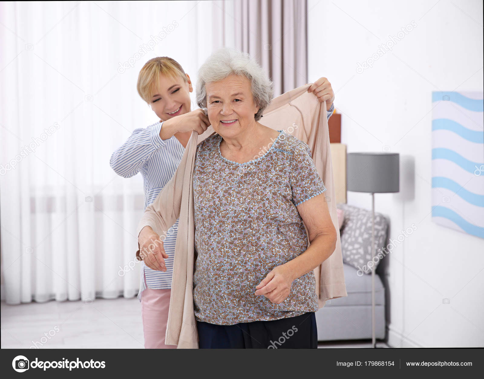 Depression In The Elderly - A Caregiver Helping An Elderly Woman Dress