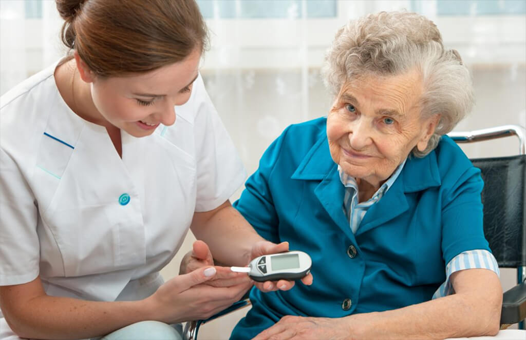 Diabetes In Seniors - A Nurse Checking An Elderly Woman's Blood Sugar