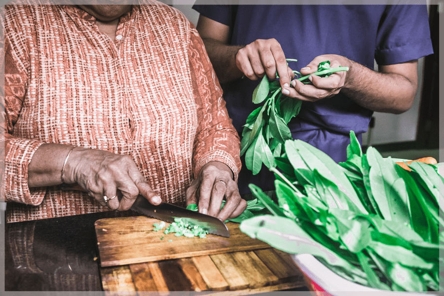 Winter Nutrition Tips - Elderly woman and caregiver chopping bok choy - MeetCaregivers