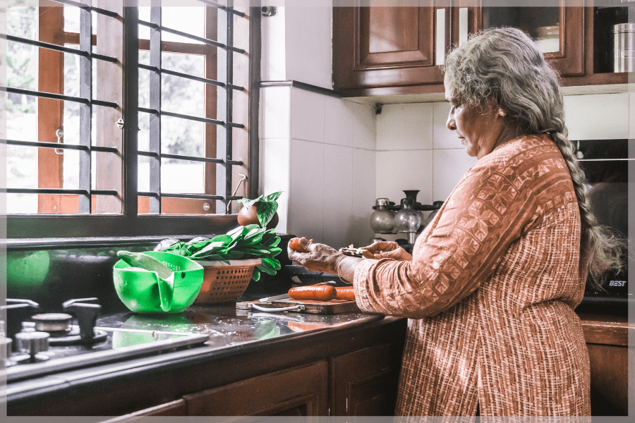 Winter Nutrition Tips - Elderly woman prepping carrots in her kitchen - MeetCaregivers