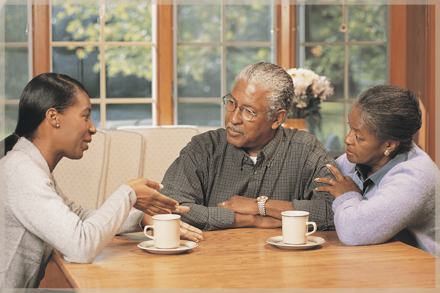 Setting boundaries with aging parents - Woman talking to her senior parents at the table - MeetCaregivers