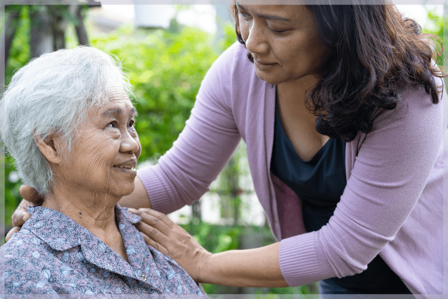 Types of caregivers - Informal caregiver assisting elderly woman outdoors - MeetCaregivers