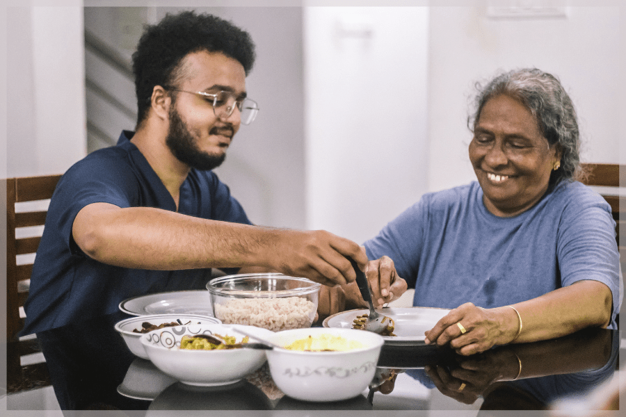 Elder abuse - Happy caregiver and patient eating breakfast - MeetCaregivers