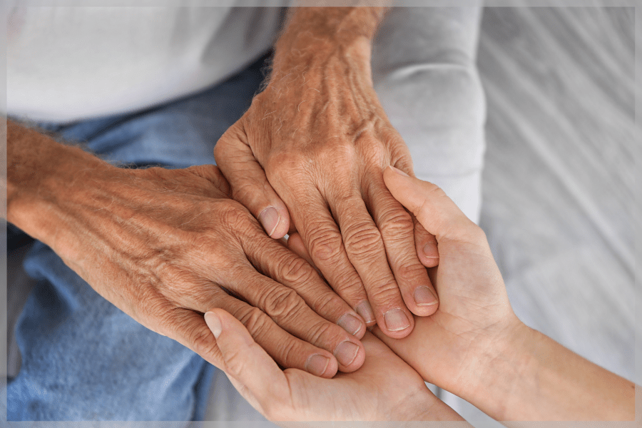 Elder abuse Young person holding an elderly adults hands in theirs MeetCaregivers