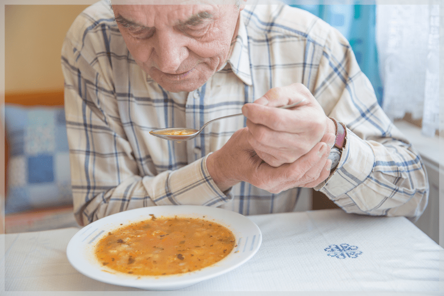 Save Your Vision Month - Elderly man with Parkinson's eating soup - MeetCaregivers