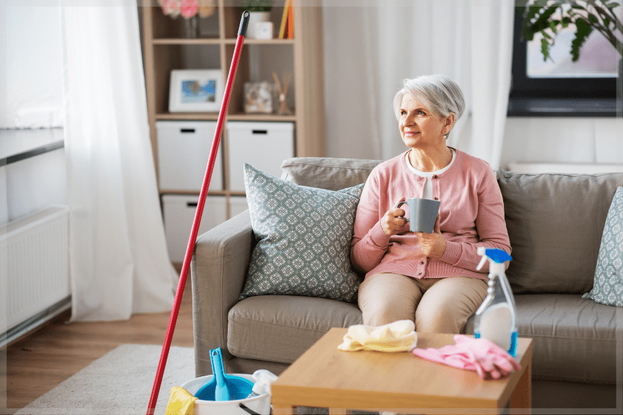 Stress Awareness Month Senior woman sitting on the couch drinking coffee after cleaning the house MeetCaregivers