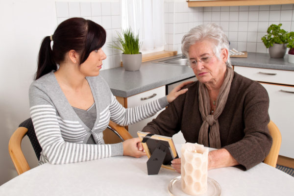 counseling-awareness-month-a-woman-talking-to-an-older-woman-looking-at-a-picture-sitting-at-a-kitchen-table