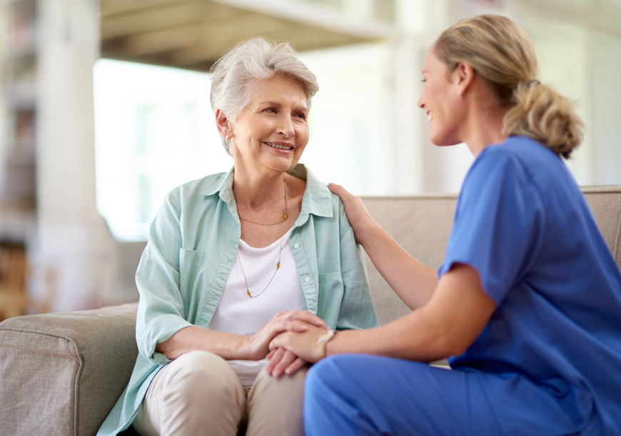 counseling-awareness-month-a-nurse-talking-to-an-older-adult-sitting-on-the-couch