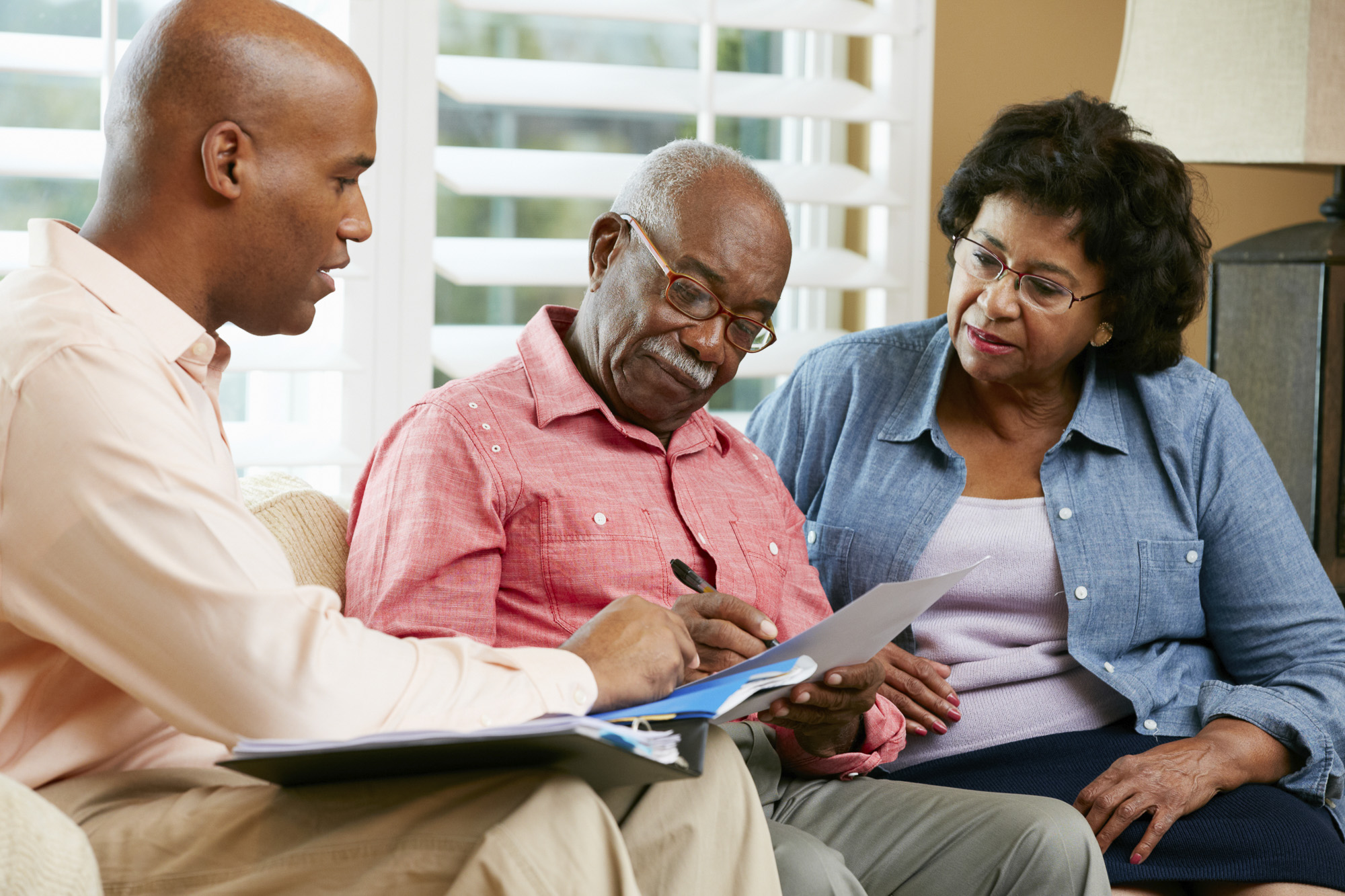 mental-health-month-a-senior-couple-talking-over-their-options-with-a-financial-advisor-at-home
