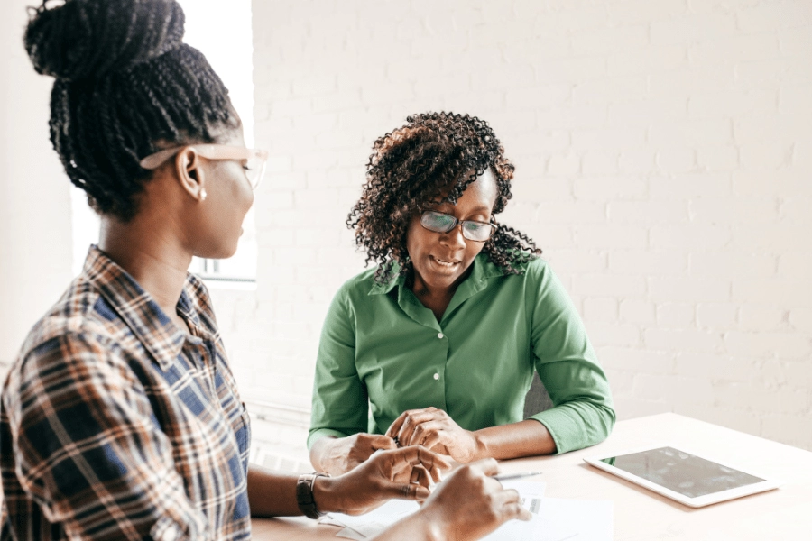 Two women discussing ways of balancing work and caregiving