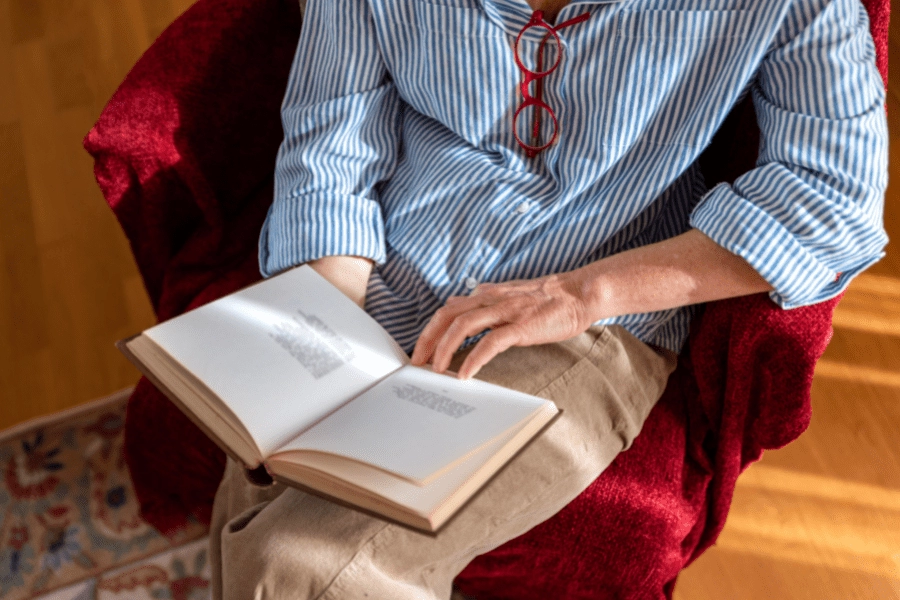Elderly man reading in an easy chair at home.