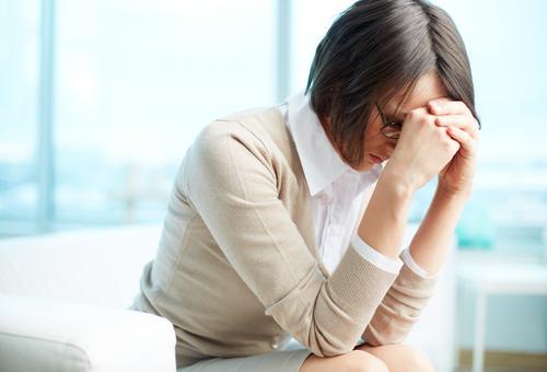 caregiver-burnout-tired-woman-holding-her-head-in-her-hands