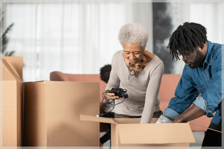 Millennial Caregivers - Younger caregiver helping his grandmother unpack boxes - MeetCaregivers