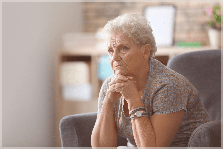 Caregiving Mistakes - Concerned elderly woman sitting in a chair - MeetCaregivers