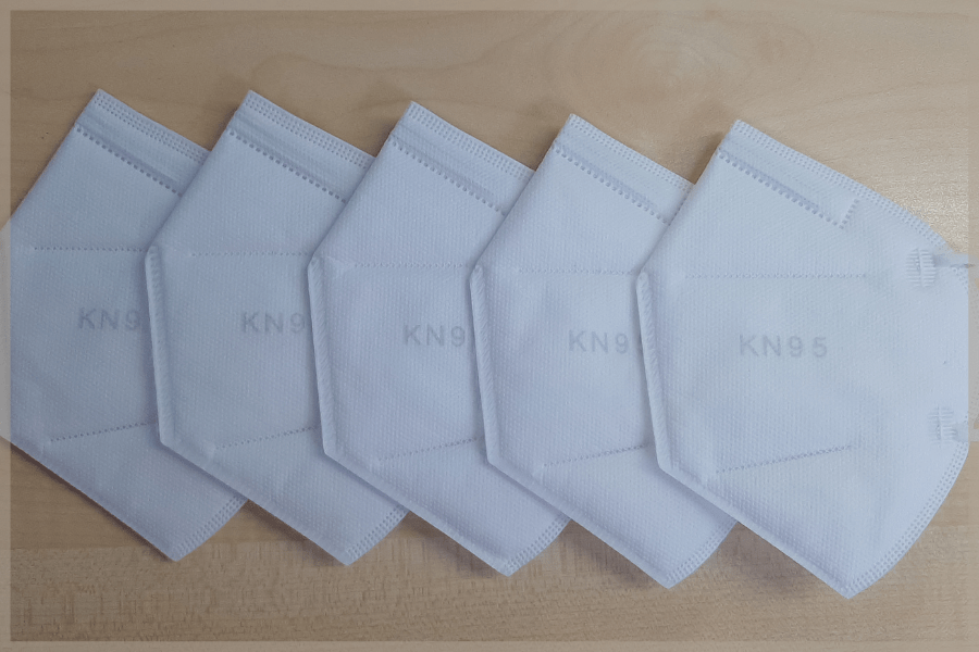 Types of face masks - A row of five KN95 masks laying on a table - MeetCaregivers