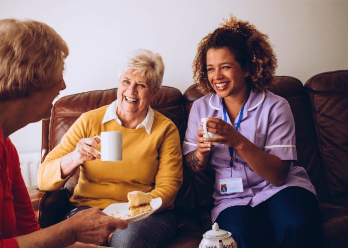 caregiver-certification-nurse-having-tea-with-two-elderly-women
