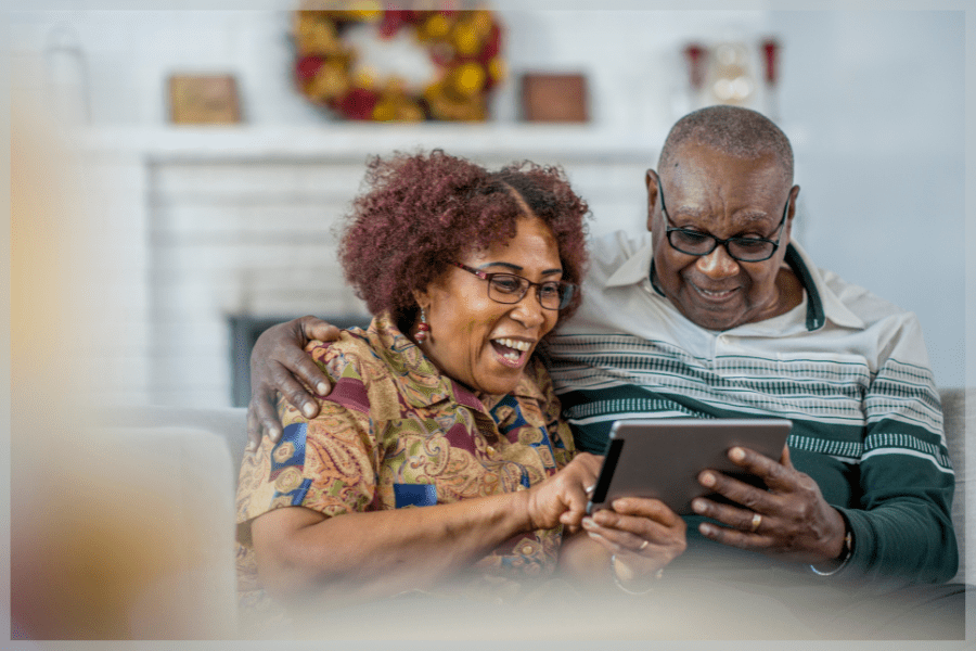 Aging in place products - Senior couple sitting in their living room using a tablet together - MeetCaregivers