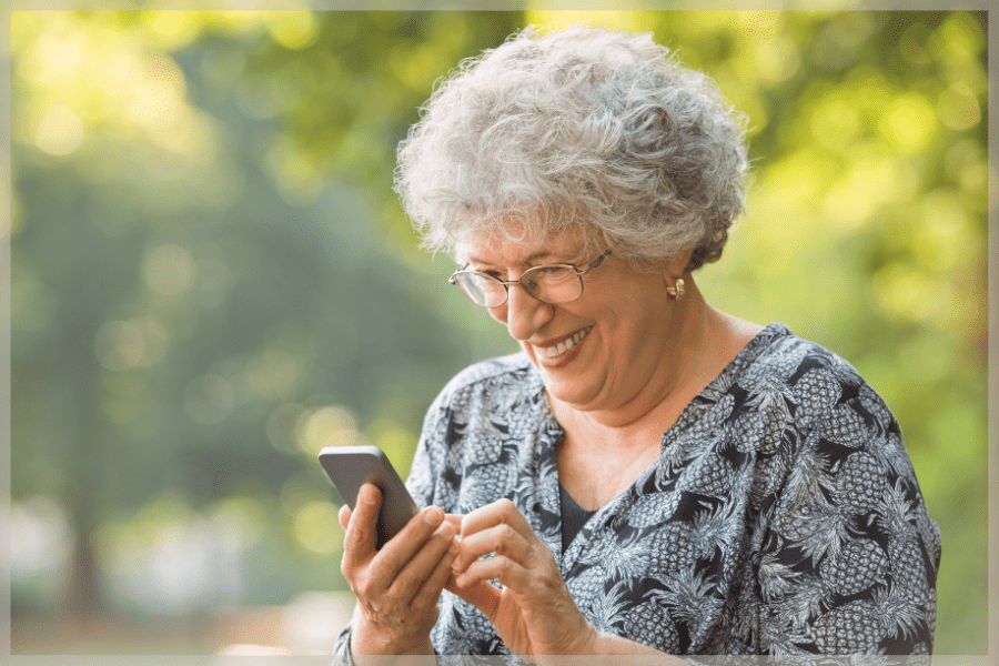 Aging in place products Smiling senior woman using her smartphone outside MeetCaregivers