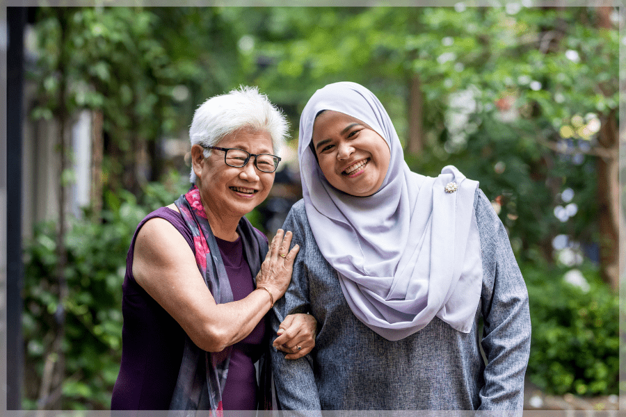 Caregiver Training - Smiling mother and daughter standing together outside - MeetCaregivers