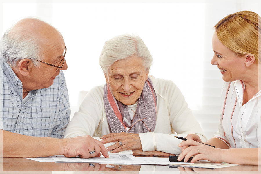 Organization Tips For Caregivers Smiling elderly couple and adult daughter going over paperwork MeetCaregivers