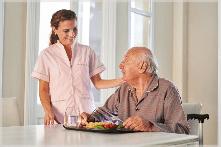 Nurse assisting elderly man with a healthy meal based on his care plan - MeetCaregivers