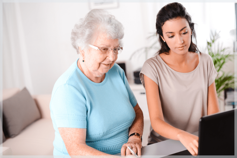 Home safety for dementia patients - Granddaughter helping her elderly grandmother on the computer - MeetCaregivers