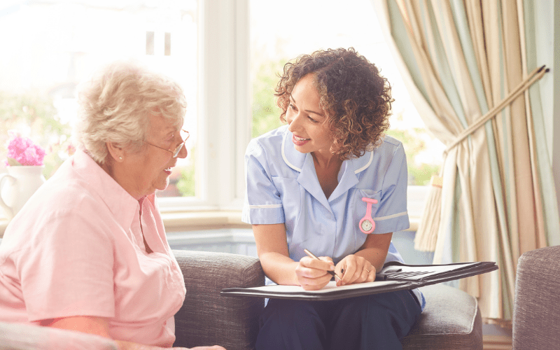 elderly woman talking to caregiver on the couch