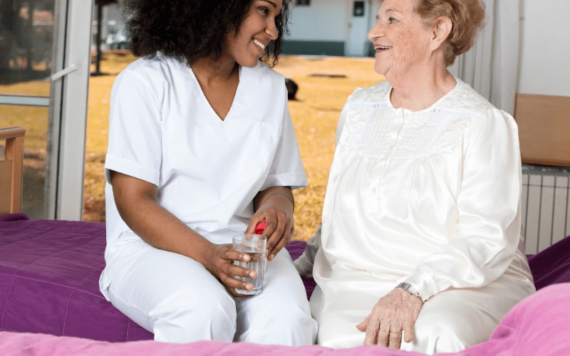 massachusetts-caregiver-talking-to-elderly-patient-in-her-room