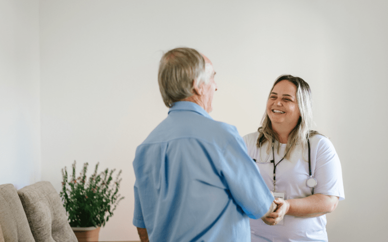 nurse greeting elderly man at home