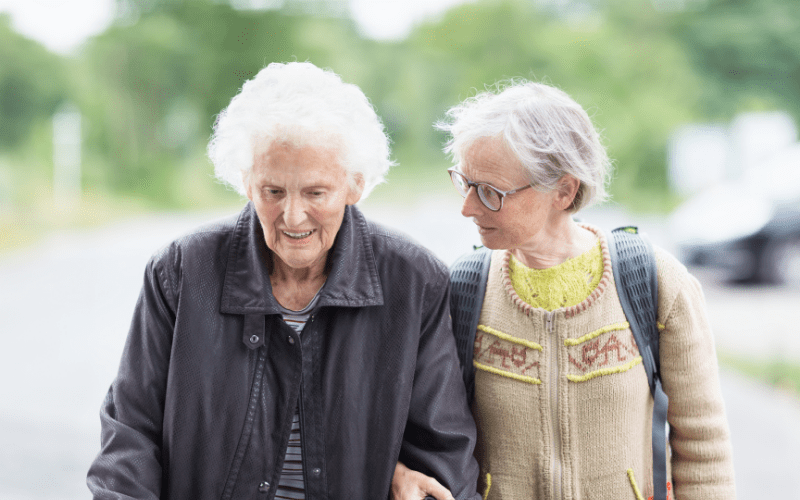 two elderly women walking together outside