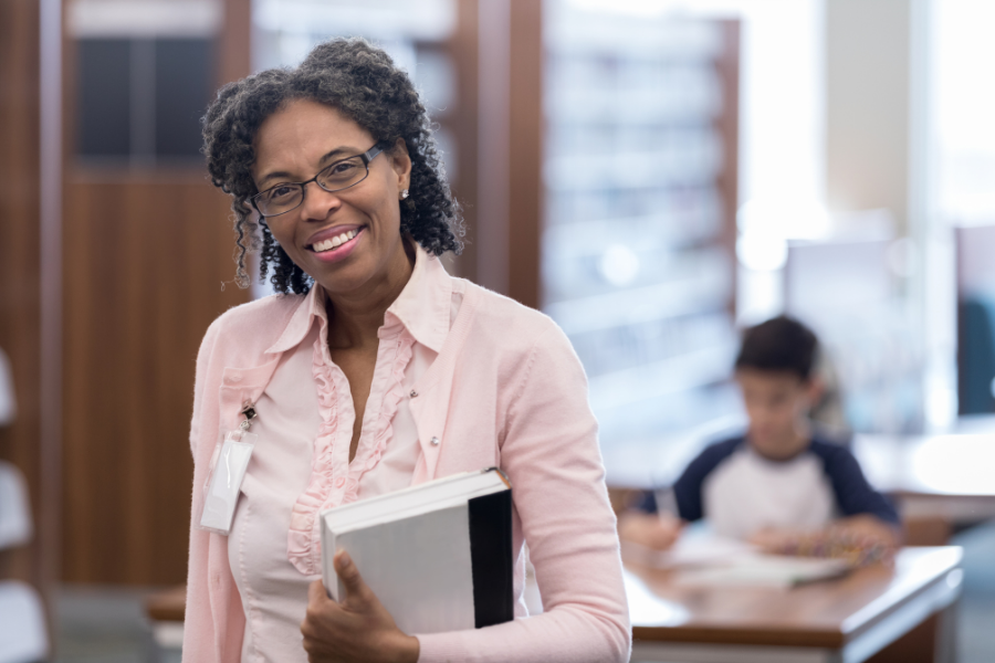 Mature adult teacher smiles cheerfully at the camera