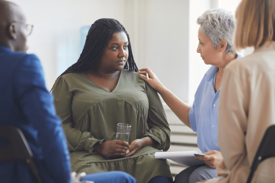 support group coach offering encouragement to timid participant