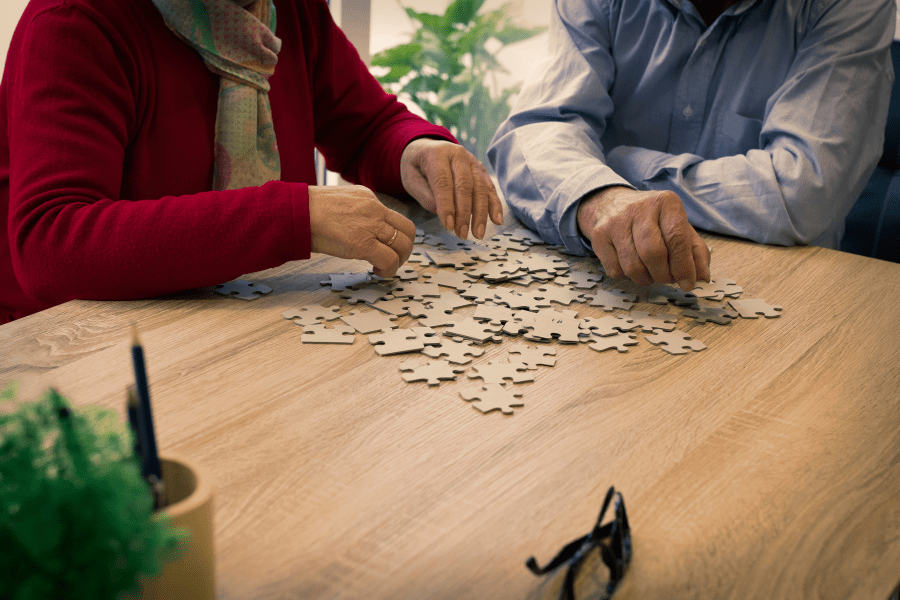 An elderly man and woman working on a puzzle together
