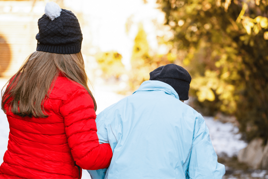 Woman walking outside with an elderly person while discussing end-of-life planning