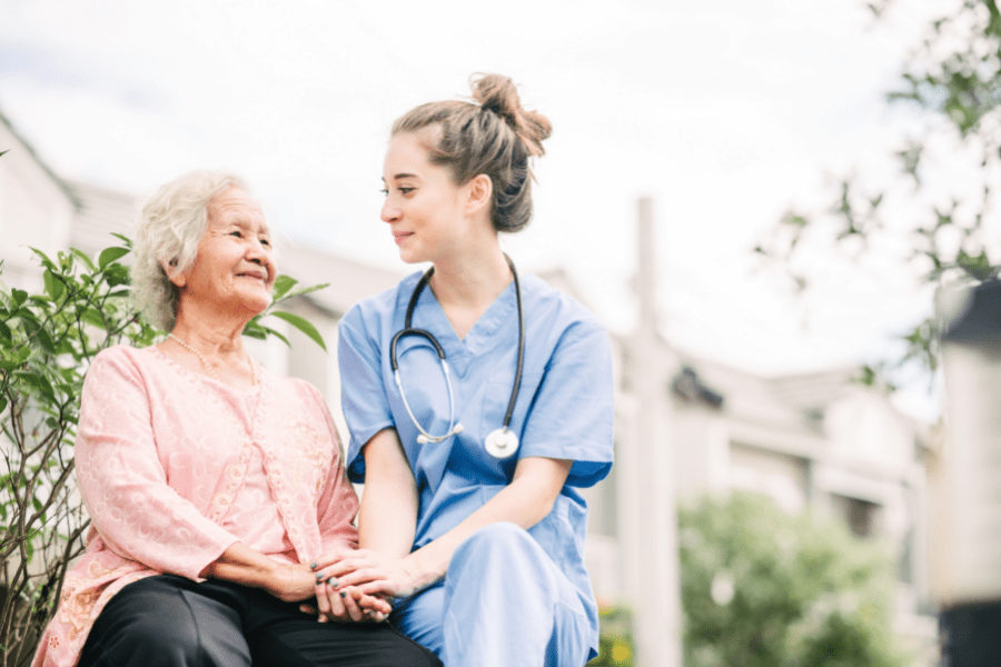 Cervical Health Awareness Month – Nurse sitting outdoors with elderly woman.