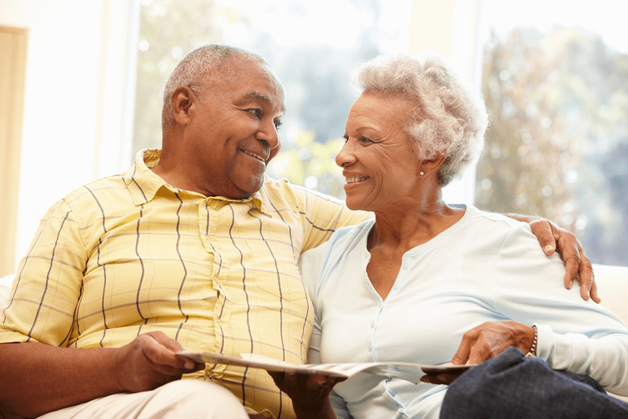 Smiling Senior Couple Reading About Long Term Care Planning