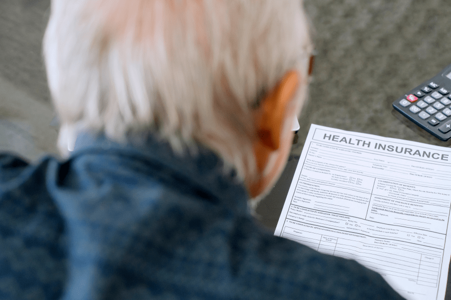 Senior man reading health plan form at home