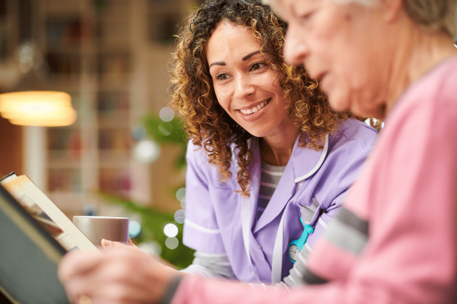 Dementia home care nurse and elderly patient looking through photo album