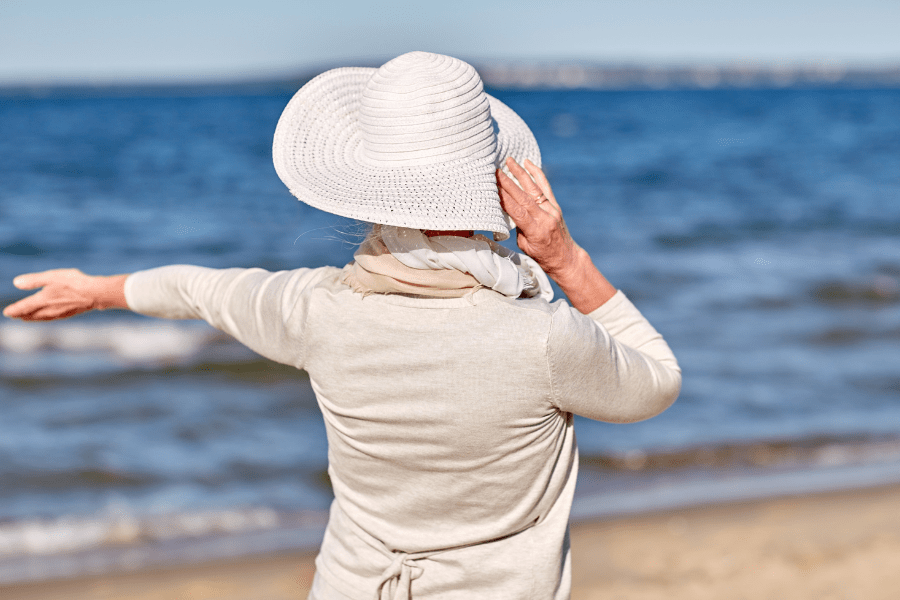 Happy Senior Woman In Sun Hat On Summer Beach