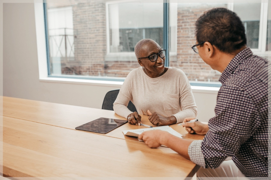 Senior resources - Senior woman and man talking at conference table - MeetCaregivers