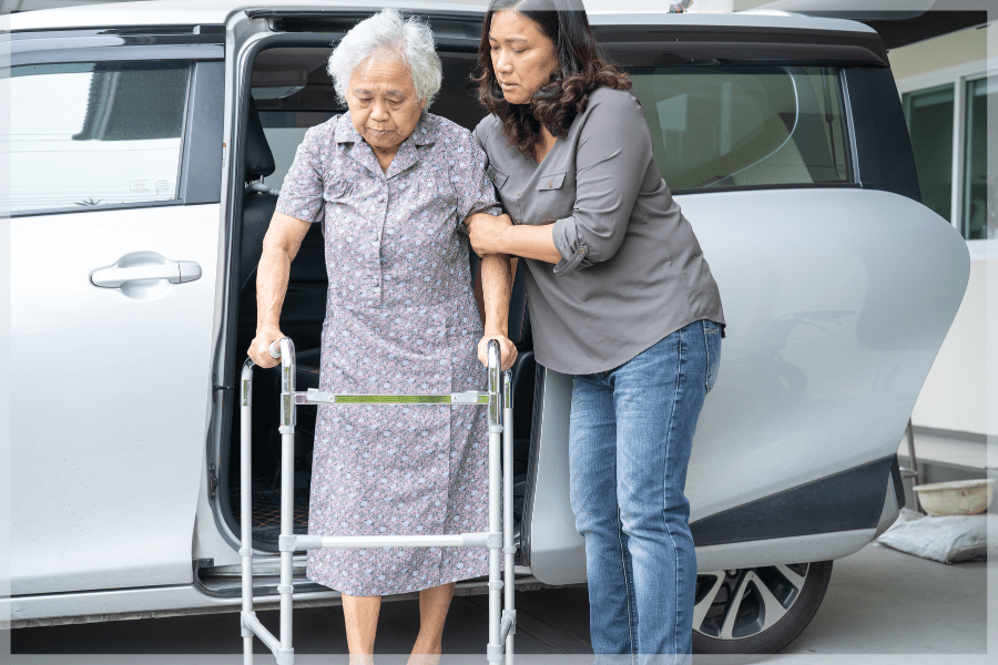 Reliable Transportation - Caregiver helping elderly woman with a walker exit a van - MeetCaregivers