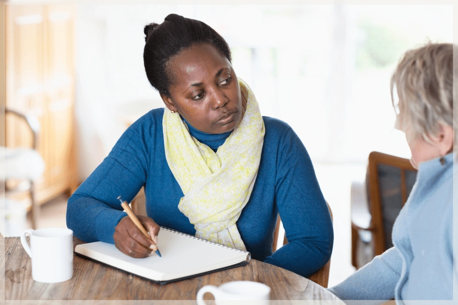 Hiring A Caregiver - Care manager taking notes while talking to client - MeetCaregivers